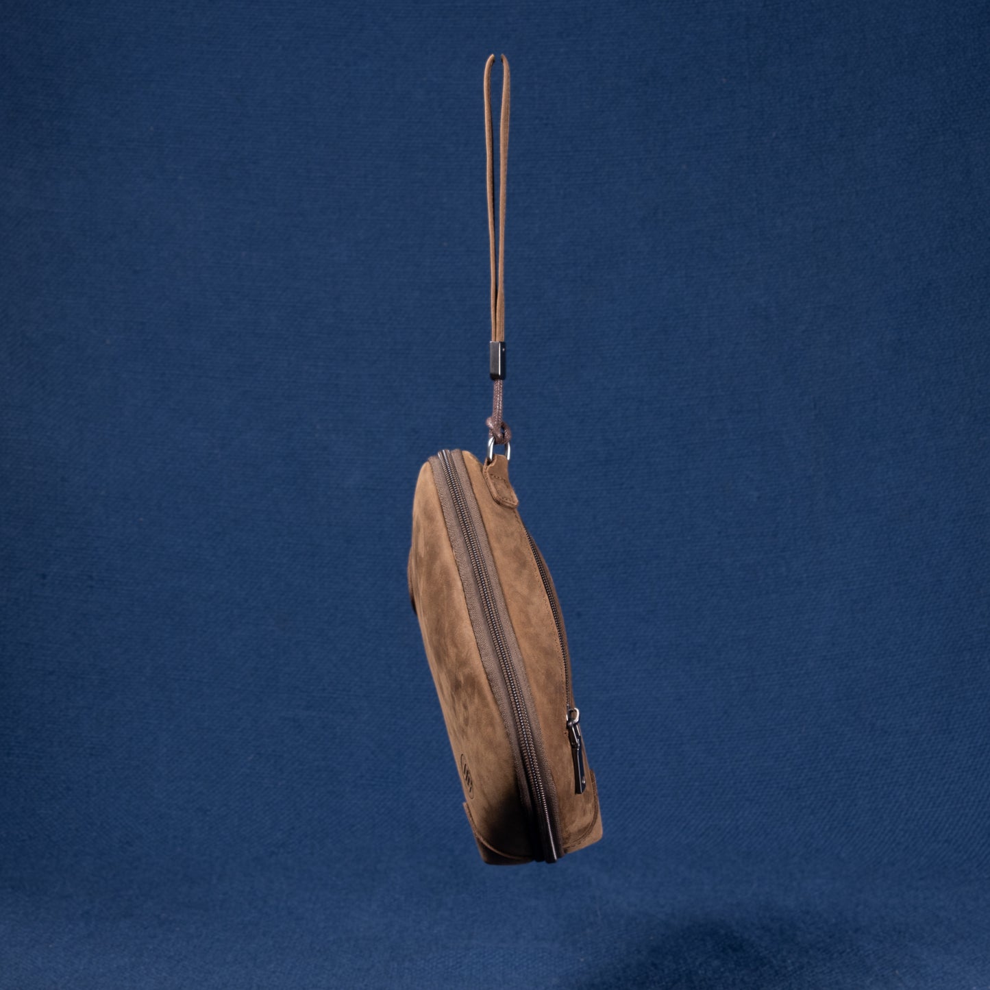 Seitenansicht der braunen Nomad Pouch mit sichtbarem Reißverschluss