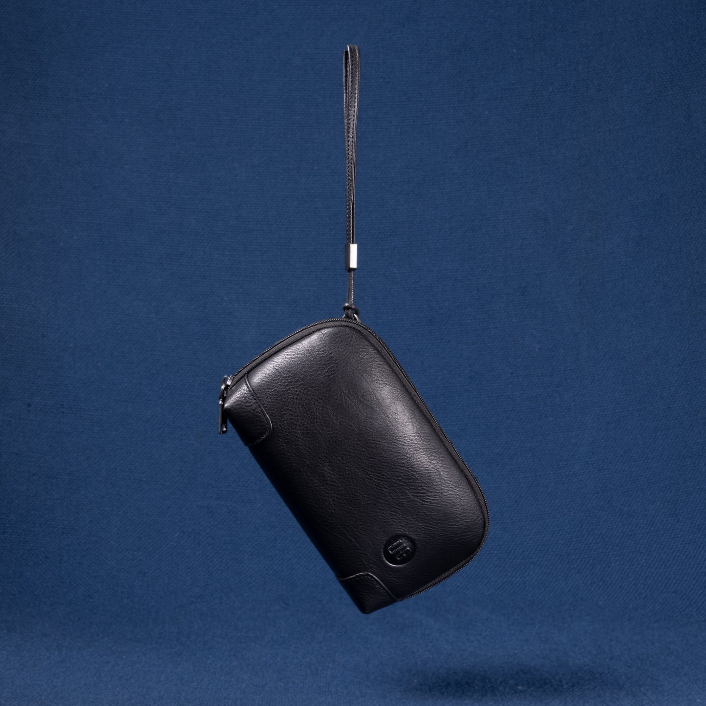 Nomad Pouch in schwarzem Echtleder – Vorderansicht mit dezenter UG-Prägung