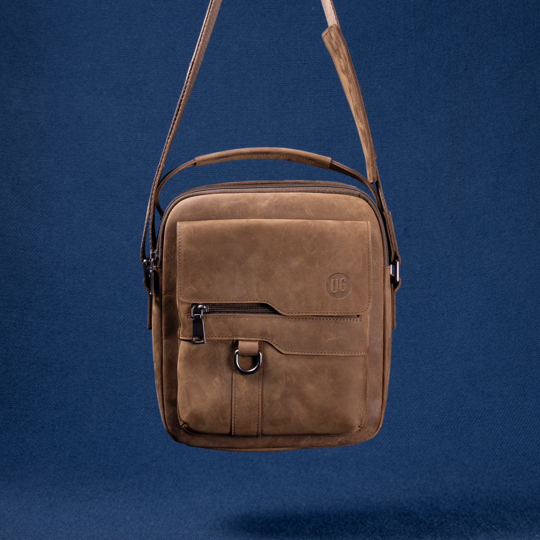 Metro Rover Bag in Cognac Suede – flach liegend, Vorderseite mit Logo-Prägung