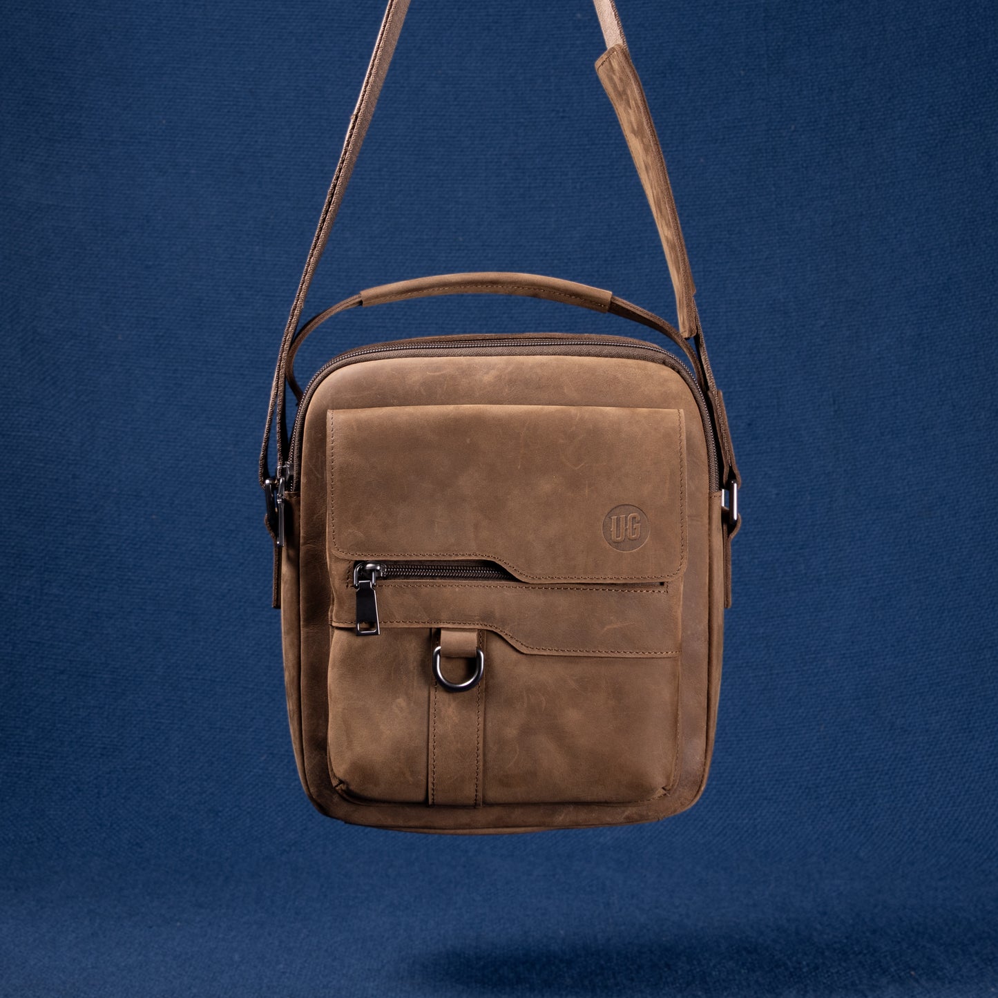 Metro Rover Bag in braunem Wildleder – flach liegend, Vorderseite mit Logo-Prägung
