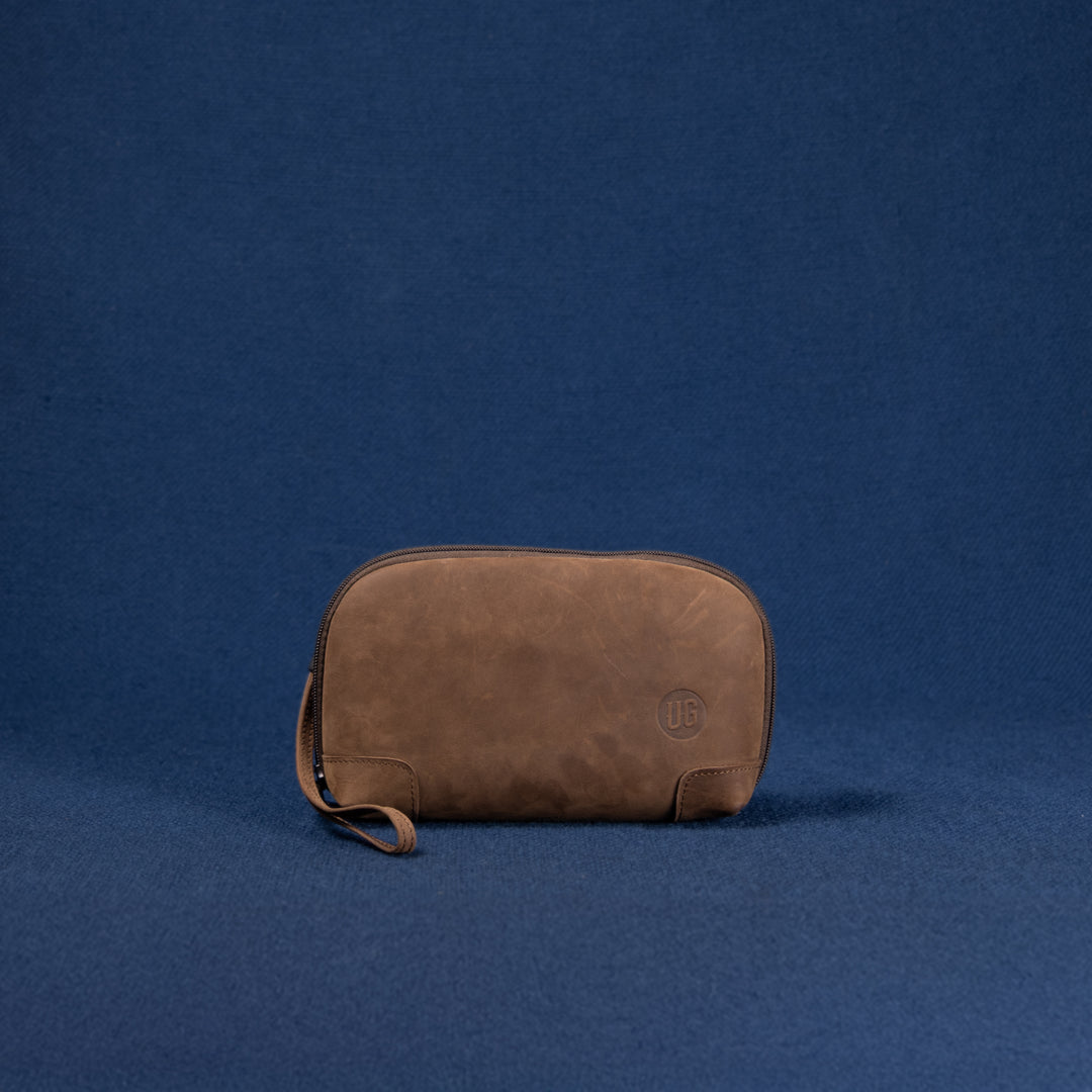 Nomad Pouch Cognac Suede – flach liegend, Vorderseite mit weicher Lederstruktur
