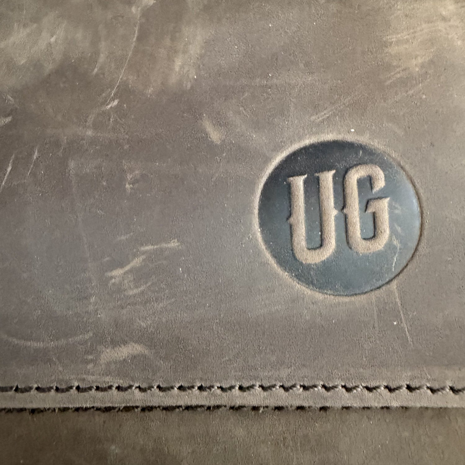 Metro Rover Bag: gepraegtes UG-Siegel auf Cognac Suede