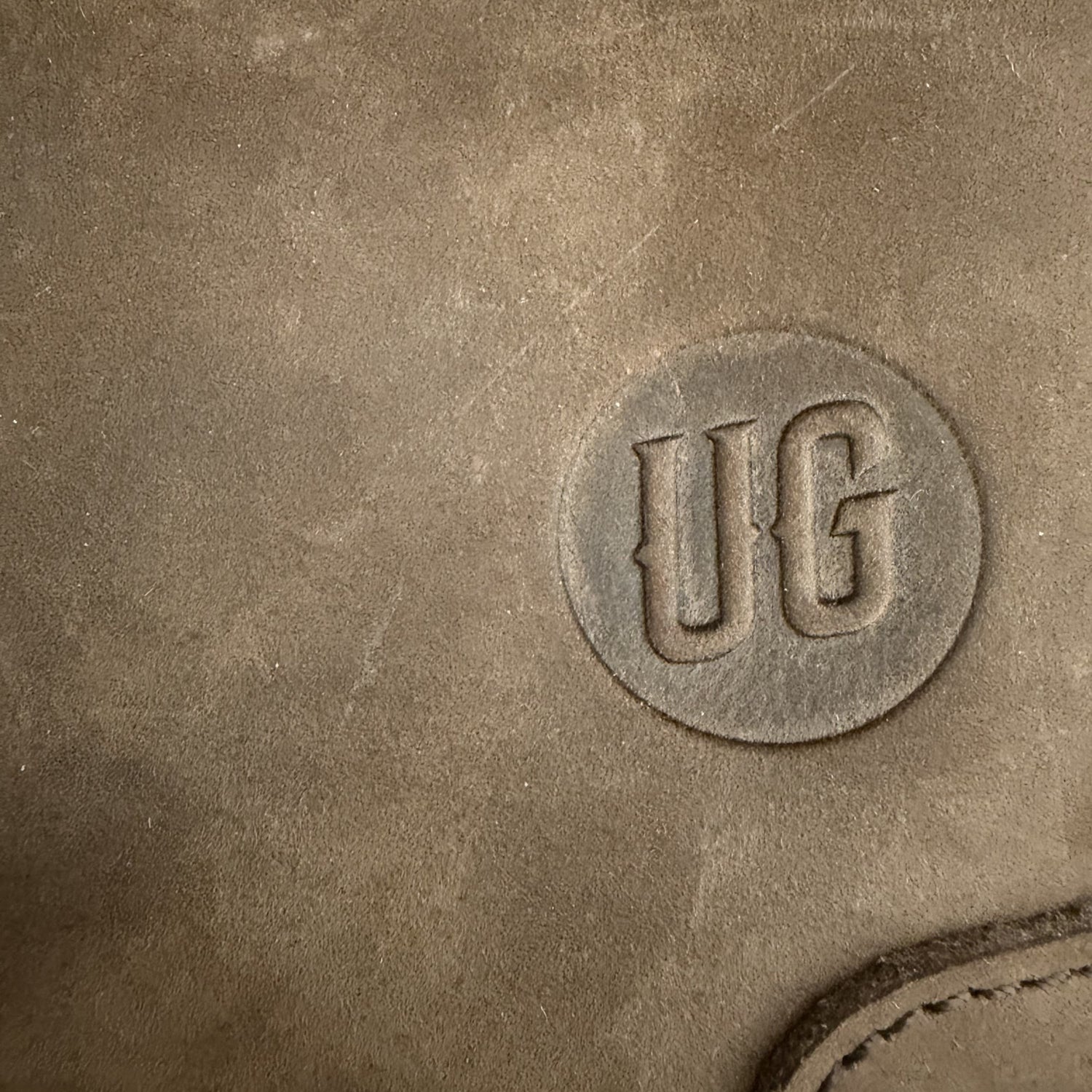 Nomad Pouch: gepraegtes UG-Siegel auf Cognac Suede