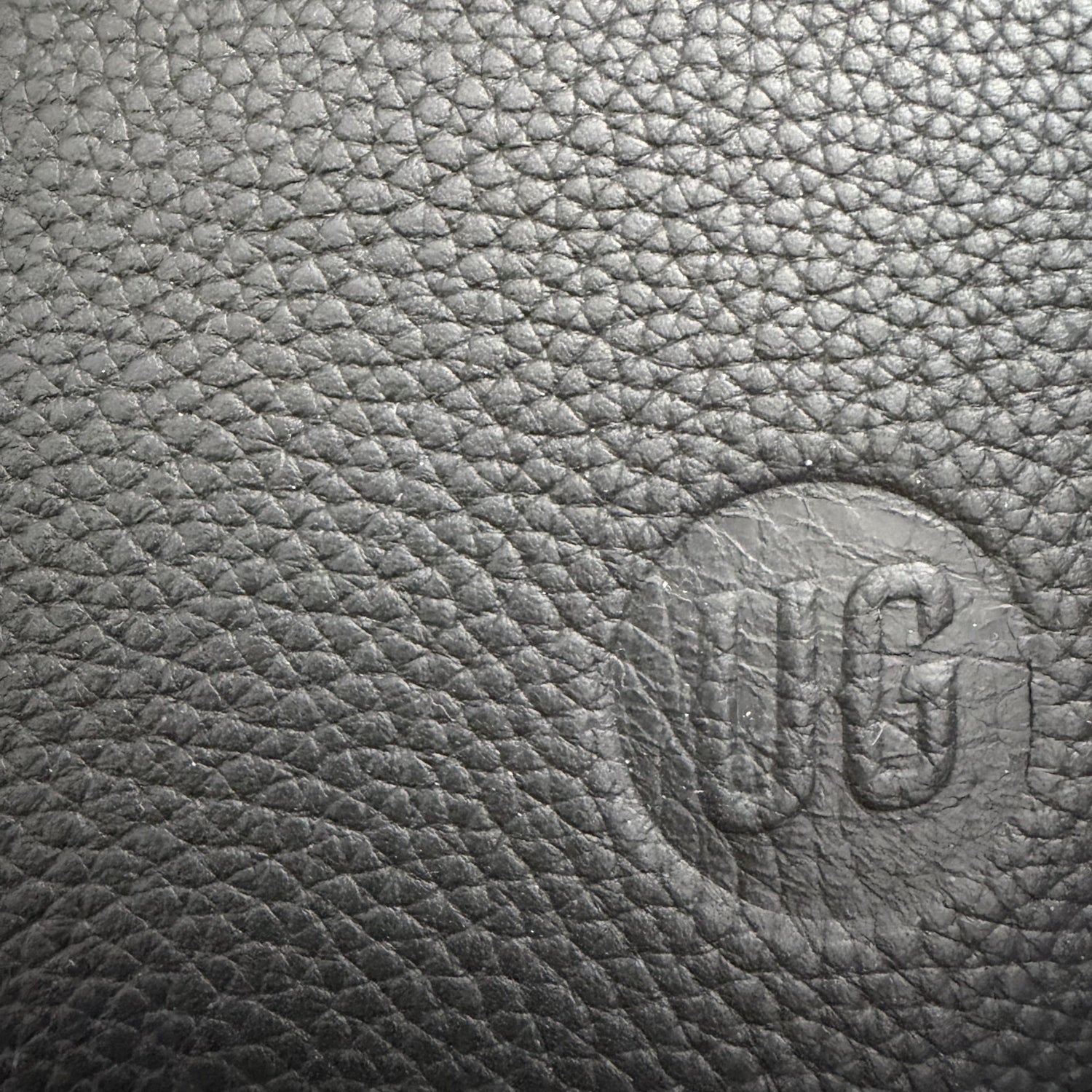 Nomad Pouch: gepraegtes UG-Siegel auf schwarzem Full-Grain Leder